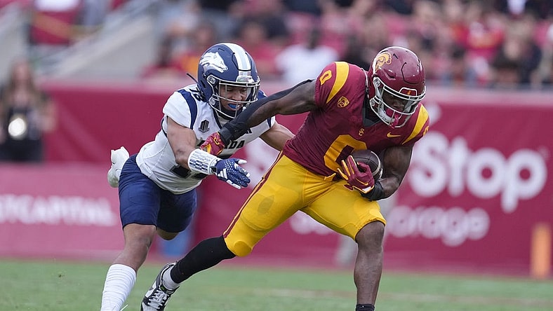 Sep 2, 2023; Los Angeles, California, USA; Southern California Trojans running back MarShawn Lloyd (0) carries the ball against Nevada Wolf Pack defensive back Ezekiel Robbins (13) in the first half at United Airlines Field at Los Angeles Memorial Coliseum. Mandatory Credit: Kirby Lee-USA TODAY Sports