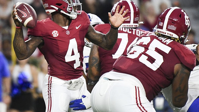 Sep 2, 2023; Tuscaloosa, Alabama, USA;  Alabama Crimson Tide quarterback Jalen Milroe (4) throws behind a block by offensive lineman JC Latham (65) against the Middle Tennessee Blue Raiders during the first half at Bryant-Denny Stadium. Mandatory Credit: Gary Cosby Jr.-USA TODAY Sports