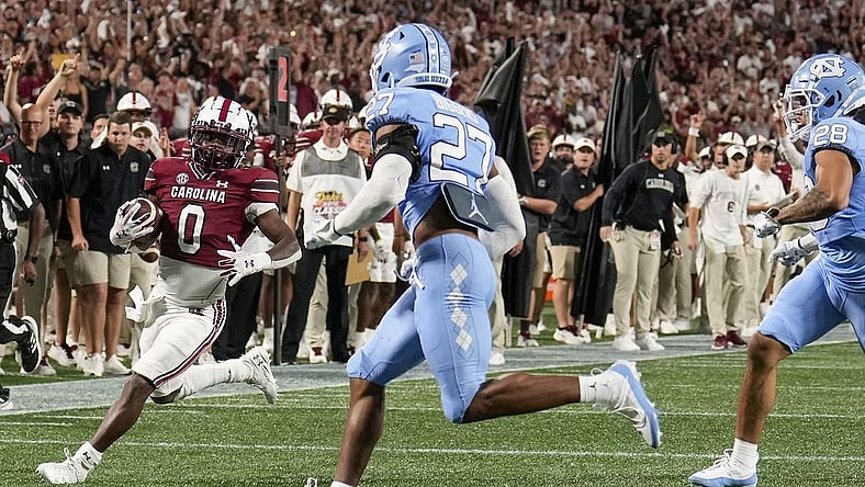 Sep 2, 2023; Charlotte, North Carolina, USA; South Carolina Gamecocks running back Juju McDowell (0) runs towards the end zone chased by North Carolina Tar Heels defensive back Giovanni Biggers (27) during the second quarter at Bank of America Stadium. Mandatory Credit: Jim Dedmon-USA TODAY Sports