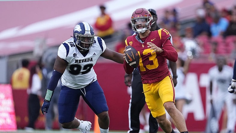 Sep 2, 2023; Los Angeles, California, USA; Southern California Trojans quarterback Caleb Williams (13) is pressured by Nevada Wolf Pack defensive end Dion Washington (92) in the second half at United Airlines Field at Los Angeles Memorial Coliseum. Mandatory Credit: Kirby Lee-USA TODAY Sports