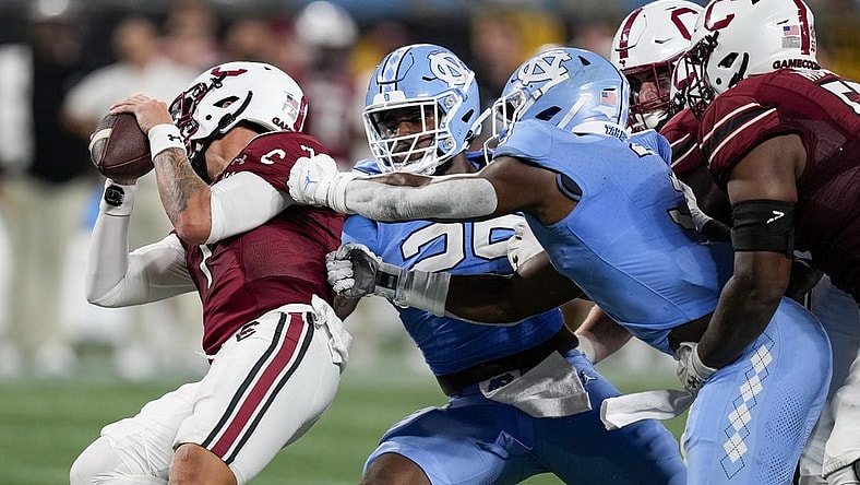 Sep 2, 2023; Charlotte, North Carolina, USA; North Carolina Tar Heels linebacker Kaimon Rucker (25) and linebacker Amari Gainer (3) tackle South Carolina Gamecocks quarterback Spencer Rattler (7) during the second half at Bank of America Stadium. Mandatory Credit: Jim Dedmon-USA TODAY Sports