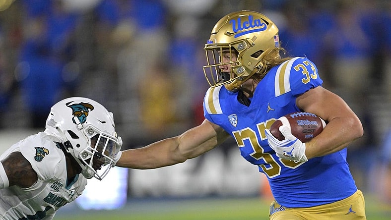 Sep 2, 2023; Pasadena, California, USA;  UCLA Bruins running back Carson Steele (33) pushes off Coastal Carolina Chanticleers safety Tobias Fletcher (4) for a first down in the first half at Rose Bowl. Mandatory Credit: Jayne Kamin-Oncea-USA TODAY Sports