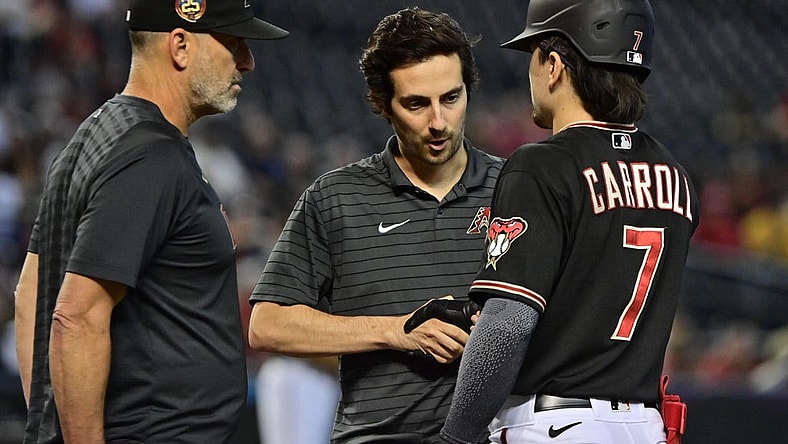 Sep 6, 2023; Phoenix, Arizona, USA; Arizona Diamondbacks left fielder Corbin Carroll (7) has his hand examined by a trainer as manager Torey Lovullo (17) looks on in the fourth inning against the Colorado Rockies at Chase Field. Mandatory Credit: Matt Kartozian-USA TODAY Sports