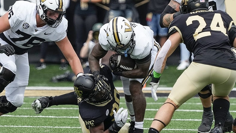 Sep 9, 2023; Winston-Salem, North Carolina, USA; Vanderbilt Commodores running back Patrick Smith (4) is tackled by Wake Forest Demon Deacons defensive lineman Jasheen Davis (30) during the first quarter at Allegacy Federal Credit Union Stadium. Mandatory Credit: Jim Dedmon-USA TODAY Sports