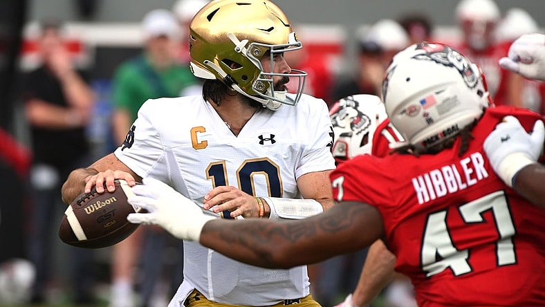 Sep 9, 2023; Raleigh, North Carolina, USA; Notre Dame Fighting Irish quarterback Sam Hartman (10) looks to pass as he is pressured by North Carolina State Wolfpack defensive lineman Jykeveous Red Hibbler(47) during the first half  at Carter-Finley Stadium. Mandatory Credit: Rob Kinnan-USA TODAY Sports