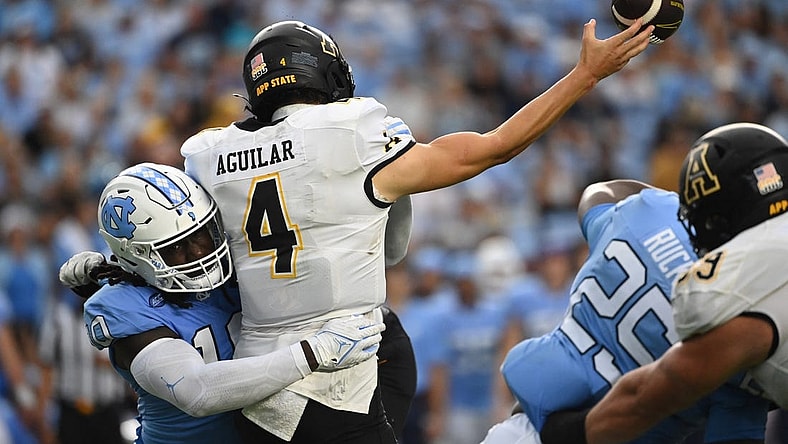 Sep 9, 2023; Chapel Hill, North Carolina, USA; Appalachian State Mountaineers quarterback Joey Aguilar (4) passes the ball as North Carolina Tar Heels defensive lineman Desmond Evans (10) pressures in the second quarter at Kenan Memorial Stadium. Mandatory Credit: Bob Donnan-USA TODAY Sports