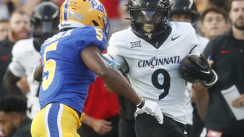 Sep 9, 2023; Pittsburgh, Pennsylvania, USA; Cincinnati Bearcats wide receiver Aaron Turner (9) carries the ball on an end around as Pittsburgh Panthers defensive back Phillip O'Brien Jr. (5) chases during the first quarter at Acrisure Stadium. Mandatory Credit: Charles LeClaire-USA TODAY Sports