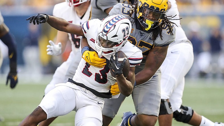 Sep 9, 2023; Morgantown, West Virginia, USA; West Virginia Mountaineers defensive lineman Mike Lockhart (93) tackles Duquesne Dukes running back JaMario Clements (23) during the second quarter at Mountaineer Field at Milan Puskar Stadium. Mandatory Credit: Ben Queen-USA TODAY Sports