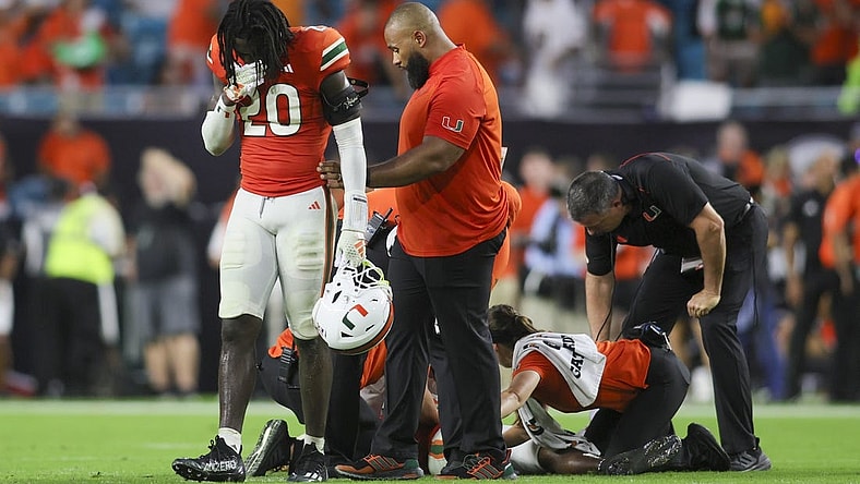 Sep 9, 2023; Miami Gardens, Florida, USA; Miami Hurricanes safety James Williams (20) reacts as trainers check on Miami Hurricanes safety Kamren Kinchens (5) after an injury against the Texas A&M Aggies during the fourth quarter at Hard Rock Stadium. Mandatory Credit: Sam Navarro-USA TODAY Sports