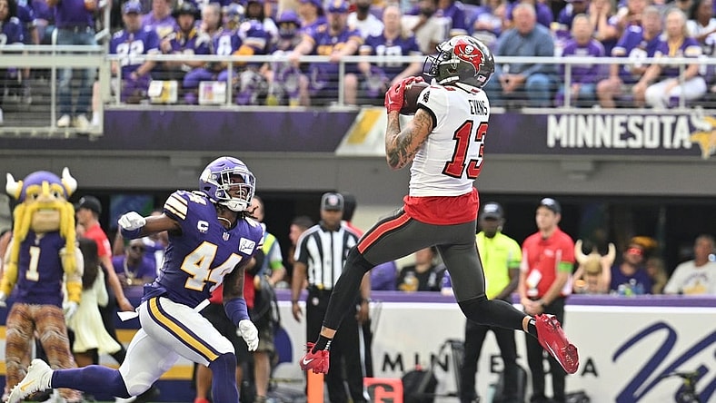 Sep 10, 2023; Minneapolis, Minnesota, USA; Tampa Bay Buccaneers wide receiver Mike Evans (13) catches a touchdown pass from quarterback Baker Mayfield (not pictured) as Minnesota Vikings safety Josh Metellus (44) defends during the second quarter at U.S. Bank Stadium. Mandatory Credit: Jeffrey Becker-USA TODAY Sports