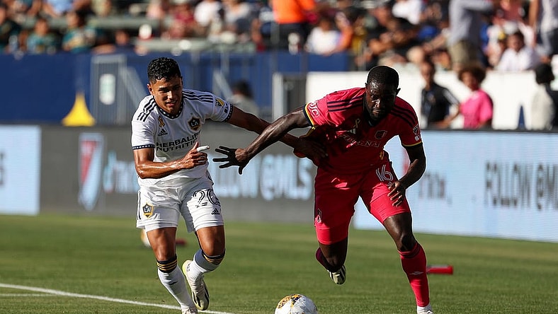 Sep 10, 2023; Carson, California, USA; St. Louis CITY SC forward Samuel Adeniran (16) controls the ball under pressure from Los Angeles Galaxy midfielder Edwin Cerrillo (20) in the first half at Dignity Health Sports Park. Mandatory Credit: Kiyoshi Mio-USA TODAY Sports