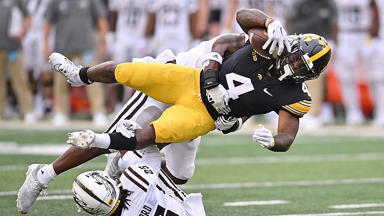 Sep 16, 2023; Iowa City, Iowa, USA; Iowa Hawkeyes running back Leshon Williams (4) runs the ball as Western Michigan Broncos cornerback Aaron Wofford (25) and linebacker Damari Roberson (rear) make the tackle during the first quarter at Kinnick Stadium. Mandatory Credit: Jeffrey Becker-USA TODAY Sports