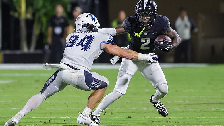Sep 16, 2023; Orlando, Florida, USA; UCF Knights wide receiver Kobe Hudson (2) runs the ball as Villanova Wildcats defensive back Ethan Potter (34) moves in during the second quarter at FBC Mortgage Stadium. Mandatory Credit: Mike Watters-USA TODAY Sports