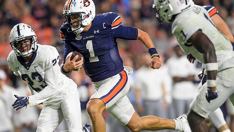 Auburn Tigers quarterback Payton Thorne (1) splts the Samford defenders, defensive back Devin Smith (23) and defensive back Kourtlan Marsh (1) as he carries for a touchdown during second half action in the AU vs. Samford game at Jordan-Hare Stadium in the AU campus in Auburn, Ala., on Saturday September 16, 2023.
