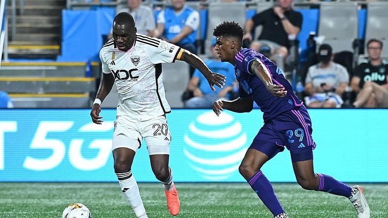 Sep 16, 2023; Charlotte, North Carolina, USA; D.C. United attacker Christian Benteke (20) dribbles the ball past Charlotte FC defender Adilson Malanda (29) in the first half at Bank of America Stadium. Mandatory Credit: Griffin Zetterberg-USA TODAY Sports
