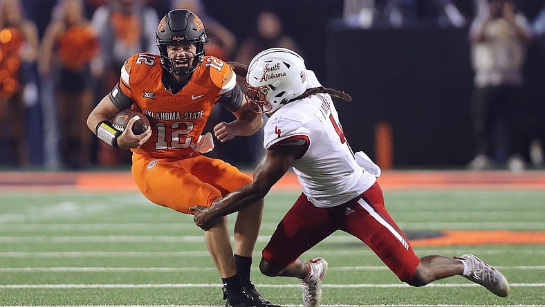 Sep 16, 2023; Stillwater, Oklahoma, USA; Oklahoma State Cowboys quarterback Gunnar Gundy (12) tries to get past South Alabama Jaguars linebacker James Miller (4) during an NCAA football game between Oklahoma State and South Alabama at Boone Pickens Stadium. South Alabama won 33-7. Mandatory Credit: Bryan Terry-USA TODAY Sports