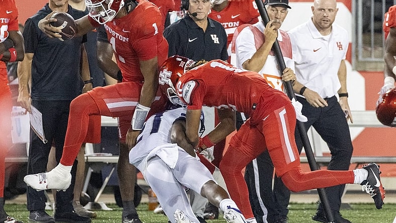 Sep 16, 2023; Houston, Texas, USA; Houston Cougars quarterback Donovan Smith (1) hurdles TCU Horned Frogs safety Bud Clark (21) in the second half at TDECU Stadium. Mandatory Credit: Thomas Shea-USA TODAY Sports