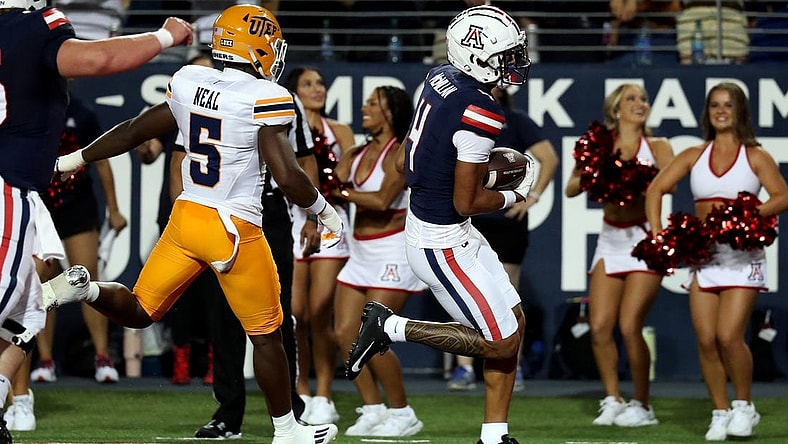 Sep 16, 2023; Tucson, Arizona, USA; Arizona Wildcats wide receiver Tetairoa McMillan (4) makes a touchdown catch against UTEP Miners linebacker James Neal (5) during the first half at Arizona Stadium. Mandatory Credit: Zachary BonDurant-USA TODAY Sports