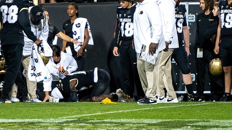 CU football's sophomore athlete Travis Hunter crumples in pain as a yellow penalty flag hits the ground following an illegal hit along the sideline by a CSU defender during the Rocky Mountain Showdown on Sept. 16, 2023 at Folsom Field in Boulder, Colo.