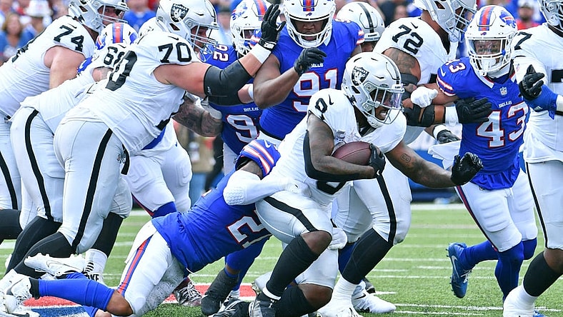 Sep 17, 2023; Orchard Park, New York, USA; Las Vegas Raiders running back Josh Jacobs (8) is tackled by Buffalo Bills safety Jordan Poyer (21) in the second quarter at Highmark Stadium. Mandatory Credit: Mark Konezny-USA TODAY Sports