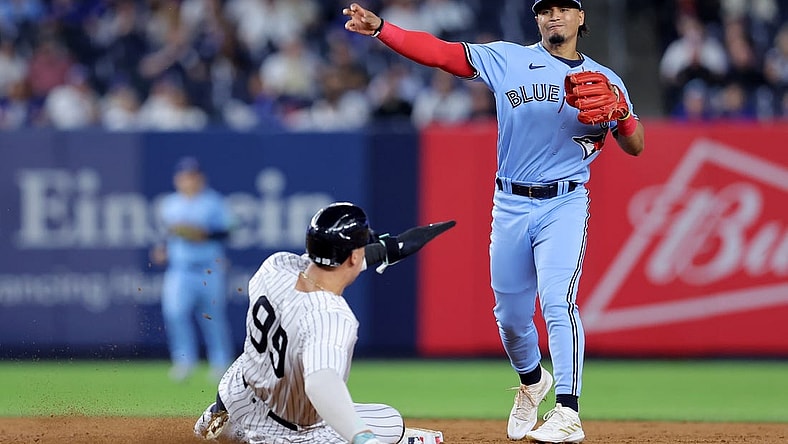 Sep 19, 2023; Bronx, New York, USA; Toronto Blue Jays second baseman Santiago Espinal (5) forces out New York Yankees right fielder Aaron Judge (99) at second and throws to first to complete a game ending double play on a ball hit by Yankees designated hitter Giancarlo Stanton (not pictured) during the ninth inning at Yankee Stadium. Mandatory Credit: Brad Penner-USA TODAY Sports