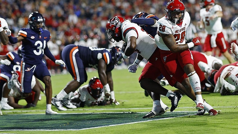 Sep 22, 2023; Charlottesville, Virginia, USA; North Carolina State Wolfpack running back Delbert Mimms III (34) scores a touchdown against the Virginia Cavaliers during the second quarter at Scott Stadium. Mandatory Credit: Geoff Burke-USA TODAY Sports