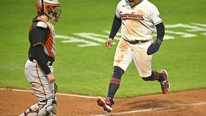 Sep 22, 2023; Cleveland, Ohio, USA; Cleveland Guardians first baseman Josh Naylor (22) scores beside Baltimore Orioles catcher Adley Rutschman (35) in the seventh inning at Progressive Field. Mandatory Credit: David Richard-USA TODAY Sports