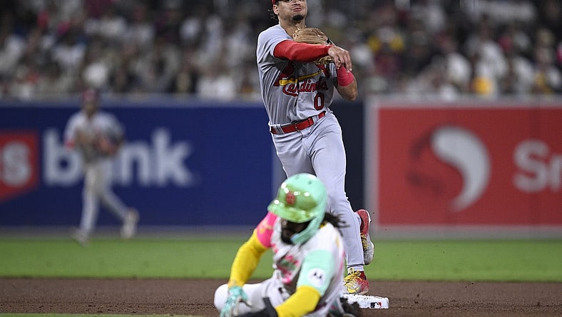 Sep 22, 2023; San Diego, California, USA; St. Louis Cardinals shortstop Masyn Winn (0) throws to first base after forcing out San Diego Padres right fielder Fernando Tatis Jr. (bottom) at second base to complete a double play during the fifth inning at Petco Park. Mandatory Credit: Orlando Ramirez-USA TODAY Sports