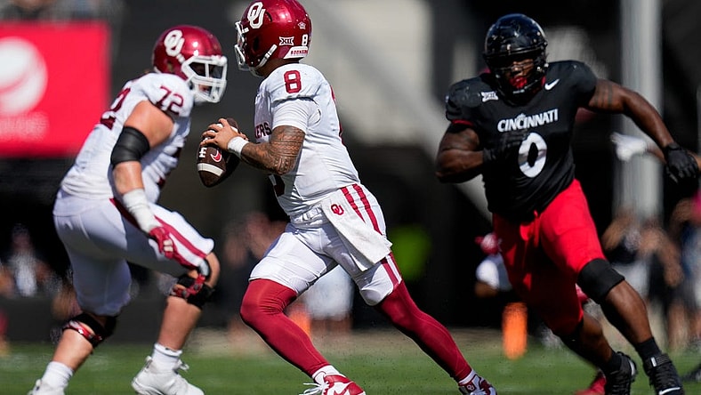 Oklahoma Sooners quarterback Dillon Gabriel (8) scrambles away from Cincinnati Bearcats defensive end Jowon Briggs (0) in the fourth quarter of the NCAA Big 12 football game between the Cincinnati Bearcats and the Oklahoma Sooners at Nippert Stadium in Cincinnati on Saturday, Sept. 23, 2023. The Bearcats lost their first Big 12 football game, 20-6, to the Sooners before a sellout crowd.