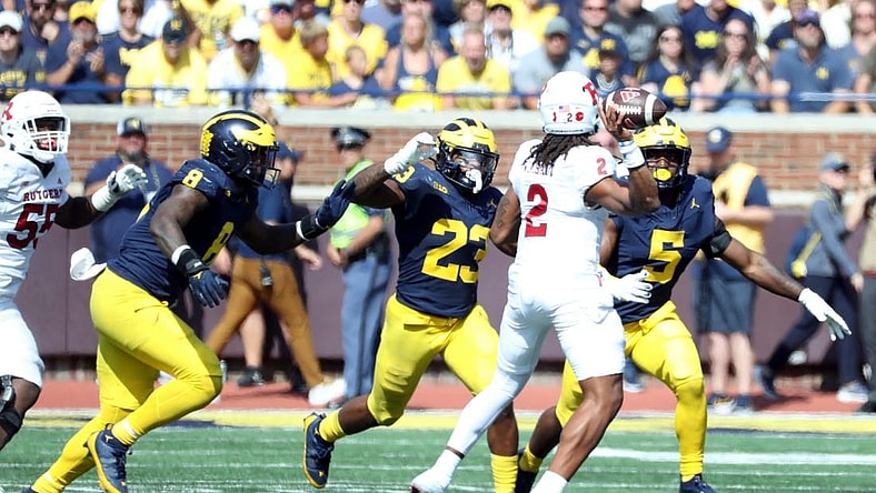 Michigan defenders, from left, Derrick Moore, Michael Barrett and Josaiah Stewart rush against Rutgers quarterback Gavin Wimsatt during the second half of Michigan's 31-7 win on Saturday, Sept. 23 2023, in Ann Arbor.