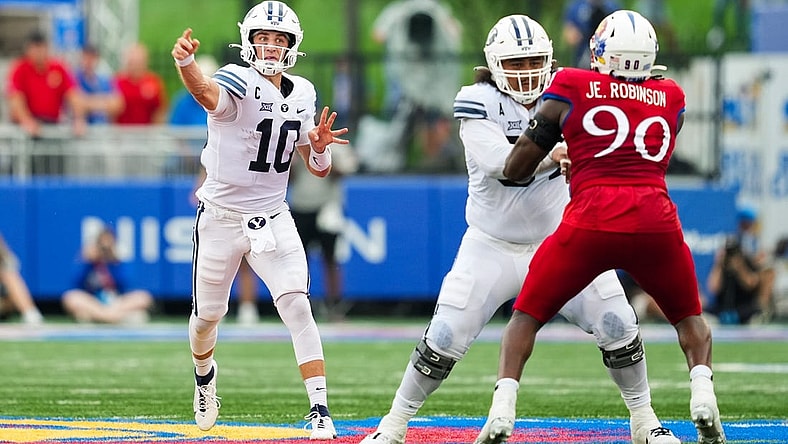 Sep 23, 2023; Lawrence, Kansas, USA; Brigham Young Cougars quarterback Kedon Slovis (10) throws a pass as Kansas Jayhawks defensive lineman Jereme Robinson (90) defends during the second half at David Booth Kansas Memorial Stadium. Mandatory Credit: Jay Biggerstaff-USA TODAY Sports