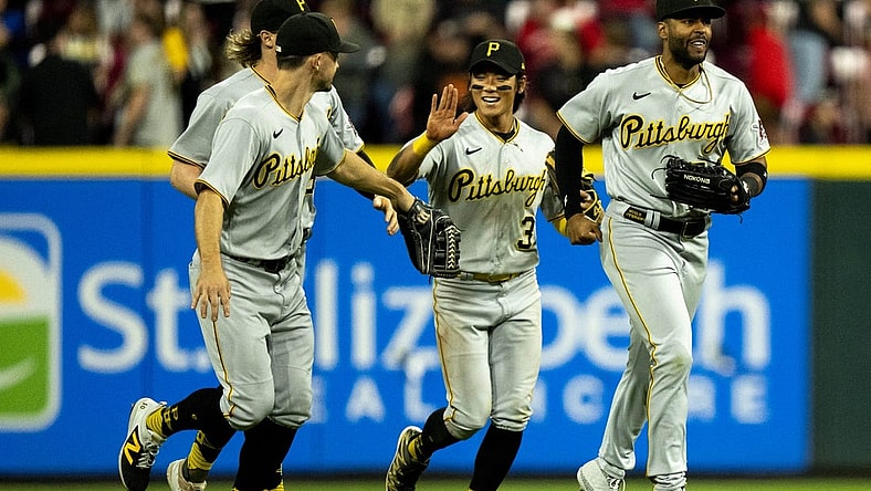 Sep 23, 2023; Cincinnati, Ohio, USA; Pittsburgh Pirates second baseman Ji Hwan Bae (3) high fives left fielder Bryan Reynolds (10) as right fielder Joshua Palacios (54), right runs ahead of them after winning at Great American Ball Park. Mandatory Credit: The Cincinnati Enquirer-USA TODAY Sports