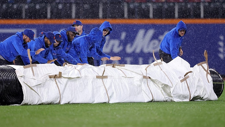 Sep 28, 2023; New York City, New York, USA; New York Mets grounds crew roll out the tarp during a rain delay during the ninth inning against the Miami Marlins at Citi Field. Mandatory Credit: Brad Penner-USA TODAY Sports