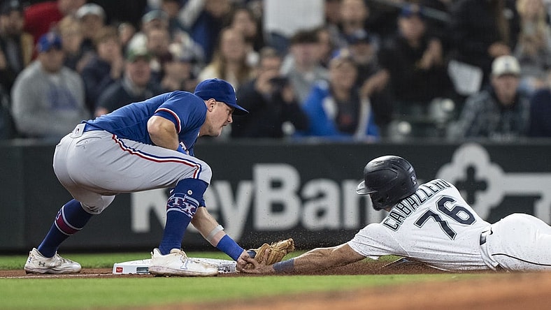 Sep 28, 2023; Seattle, Washington, USA; Texas Rangers third baseman Josh Jung (6) tags out Seattle Mariners second baseman Jose Caballero (76) after Caballero tried to reach third base on a single by shortstop J.P. Crawford (3) during the fifth inning at T-Mobile Park. Mandatory Credit: Stephen Brashear-USA TODAY Sports