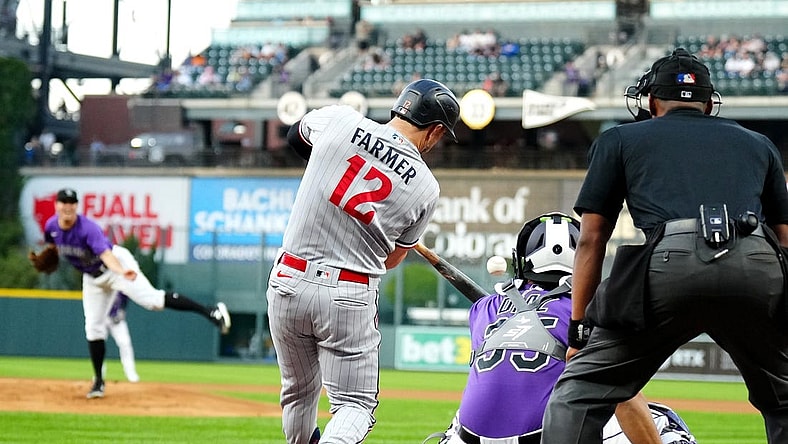 Sep 29, 2023; Denver, Colorado, USA; Minnesota Twins short stop Kyle Farmer (12) RBI singles in the first inning against the Colorado Rockies at Coors Field. Mandatory Credit: Ron Chenoy-USA TODAY Sports