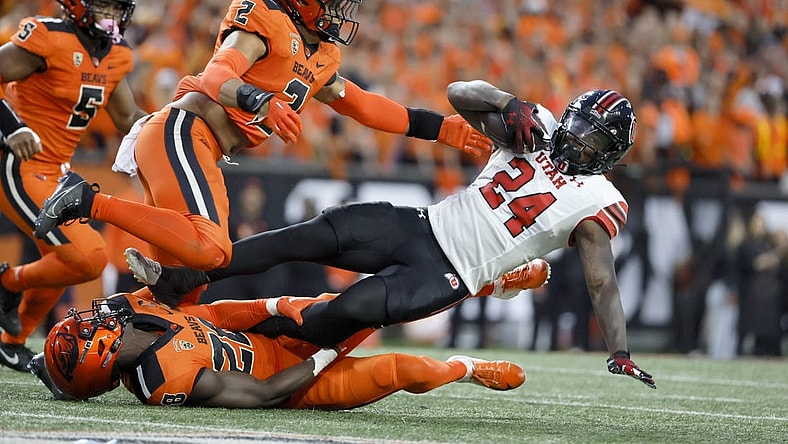 Sep 29, 2023; Corvallis, Oregon, USA; Utah Utes running back Chris Curry (24) is tackled by Oregon State Beavers defensive back Kitan Oladapo (28) during the first half at Reser Stadium. Mandatory Credit: Soobum Im-USA TODAY Sports