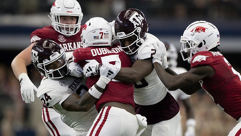 Sep 30, 2023; Arlington, Texas, USA; Arkansas Razorbacks running back Rashod Dubinion (7) is tackled by Texas A&M Aggies linebacker Chris Russell Jr. (24) and defensive back Jacoby Mathews (2) during the first half at AT&T Stadium. Mandatory Credit: Jerome Miron-USA TODAY Sports