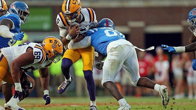 Sep 30, 2023; Oxford, Mississippi, USA; LSU Tigers quarterback Jayden Daniels (5) runs with the ball as Mississippi Rebels linebacker Monty Montgomery (8) makes the tackle during the first half at Vaught-Hemingway Stadium. Mandatory Credit: Petre Thomas-USA TODAY Sports