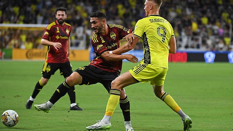 Sep 30, 2023; Nashville, Tennessee, USA; Seattle Sounders FC midfielder Cristian Roldan (7) plays the ball against Nashville SC forward Sam Surridge (9) during the first half at Geodis Park. Mandatory Credit: Christopher Hanewinckel-USA TODAY Sports