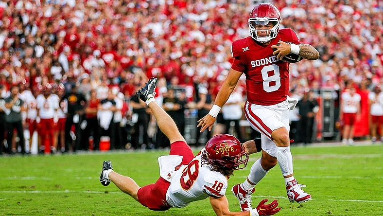 Oklahoma's Dillon Gabriel (8) runs the ball and jumps over Iowa State's Ben Nikkel (18) to score a touchdown in the first quarter during an NCAA football game between University of Oklahoma (OU) and Iowa State at the Gaylord Family Oklahoma Memorial Stadium in Norman, Okla., on Saturday, Sept. 30, 2023.