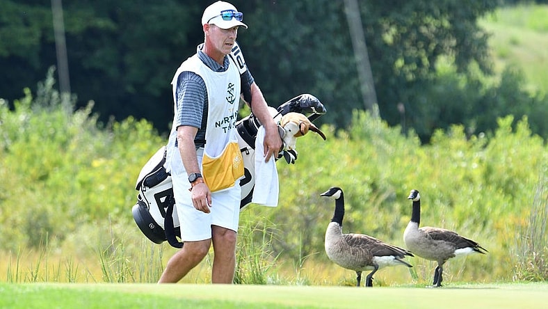 Aug 23, 2020; Norton, Massachusetts, USA; Caddie Phillip Lowe tries to shoo geese off the 2nd green at TPC of Boston. Mandatory Credit: Mark Konezny-USA TODAY Sports
