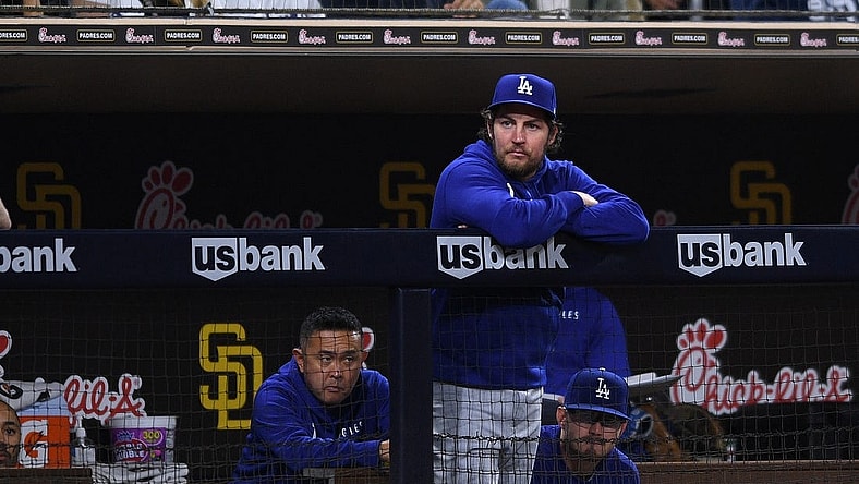 Jun 22, 2021; San Diego, California, USA; Los Angeles Dodgers starting pitcher Trevor Bauer (top) looks on from the dugout during the fifth inning against the San Diego Padres at Petco Park. Mandatory Credit: Orlando Ramirez-USA TODAY Sports
