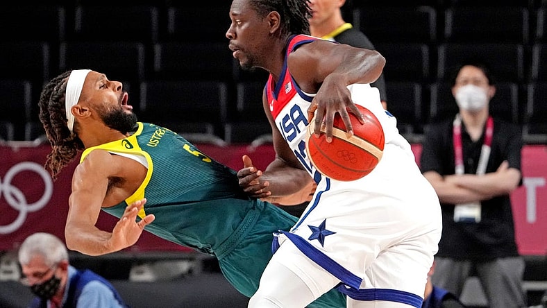 Aug 5, 2021; Saitama, Japan; United States guard Jrue Holiday (12) drives to the basket against Australia point guard Patty Mills (5) in the men's basketball semi final during the Tokyo 2020 Olympic Summer Games at Saitama Super Arena. Mandatory Credit: Kyle Terada-USA TODAY Sports