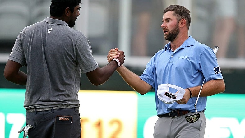 Oct 2, 2021; Jackson, Mississippi, USA; Sahith Theegala and Cameron Young shake hands on the 18th green after their third round of the Sanderson Farms Championship at the Country Club of Jackson. Mandatory Credit: Chuck Cook-USA TODAY Sports