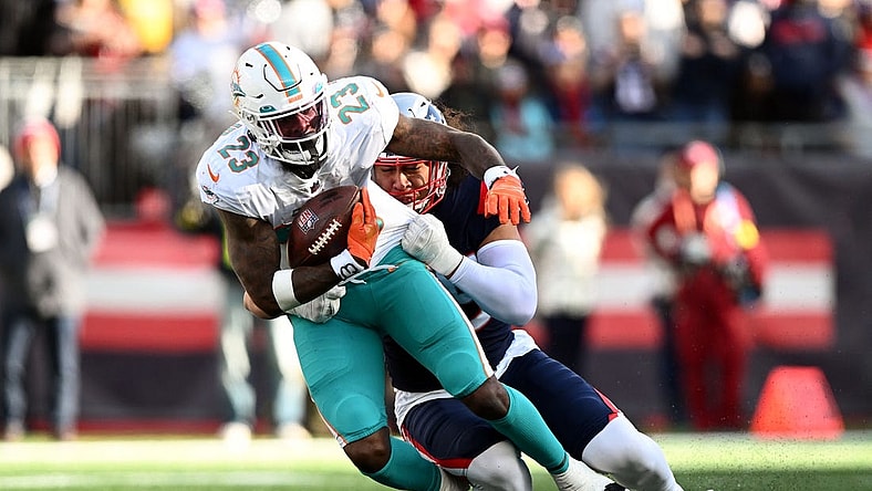 Jan 1, 2023; Foxborough, Massachusetts, USA; New England Patriots linebacker Jahlani Tavai (48) tackles Miami Dolphins running back Jeff Wilson Jr. (23) during the first half at Gillette Stadium. Mandatory Credit: Brian Fluharty-USA TODAY Sports