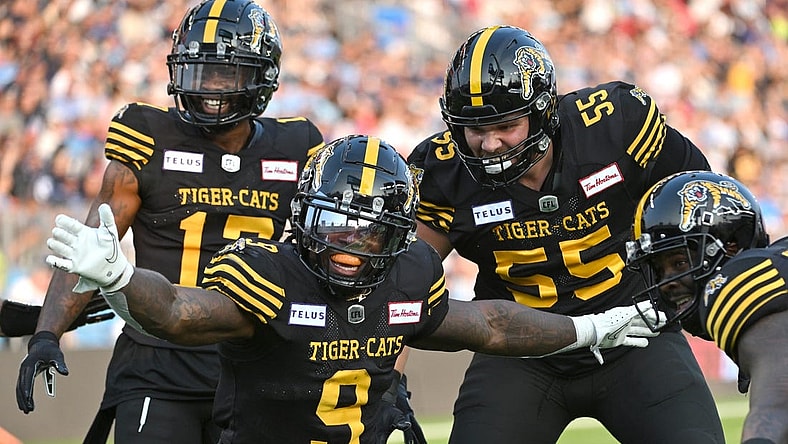 Jun 18, 2023; Toronto, Ontario, CAN;  Hamilton Tiger-Cats quarter James Butler (9) celebrates with teammates after scoring a touchdown against the Toronto Argonauts in the second quarter at BMO Field. Mandatory Credit: Dan Hamilton-USA TODAY Sports