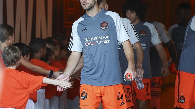 Aug 30, 2023; Houston, Texas, USA; Houston Dynamo FC defender Ethan Bartlow (4) and Dynamo FC players greet children in the tunnel before the match against the Columbus Crew SC at Shell Energy Stadium. Mandatory Credit: Troy Taormina-USA TODAY Sports