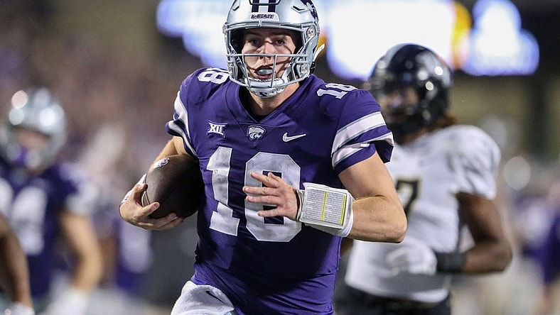 Sep 23, 2023; Manhattan, Kansas, USA; Kansas State Wildcats quarterback Will Howard (18) runs away from several UCF Knights defenders to score a touchdown late in the fourth quarter at Bill Snyder Family Football Stadium. Mandatory Credit: Scott Sewell-USA TODAY Sports