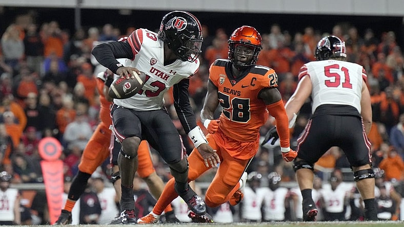 Sep 29, 2023; Corvallis, Oregon, USA; Utah Utes quarterback Nate Johnson (13) scrambles under pressure from Oregon State Beavers defensive back Kitan Oladapo (28) during the second half at Reser Stadium. Mandatory Credit: Soobum Im-USA TODAY Sports