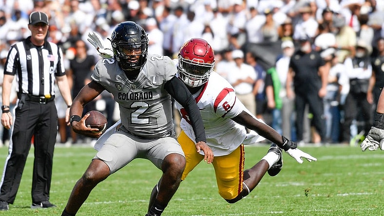 Sep 30, 2023; Boulder, Colorado, USA; Colorado Buffaloes quarterback Shedeur Sanders (2) attempts to scramble from USC Trojans defensive lineman Anthony Lucas (6) during the fourth quarter at Folsom Field. Mandatory Credit: John Leyba-USA TODAY Sports